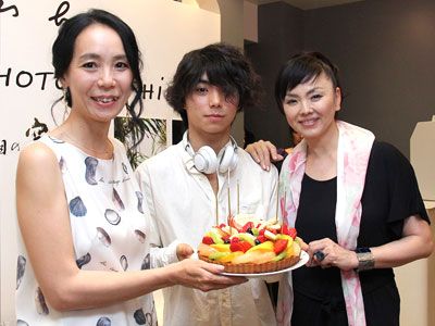 祝福のケーキを手に笑顔を見せる河瀬直美監督と村上虹郎、松田美由紀