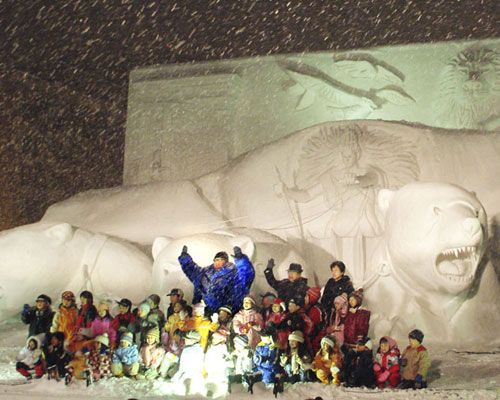 『ナルニア国物語／第1章：ライオンと魔女』の大雪像の前でKONISHIKIと子どもたちが大合唱（青いコートを着ているのがKONISHIKI）
