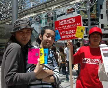 ゲド本を手に入れた渋谷の若者と真っ赤なティーシャツを着た配布者。