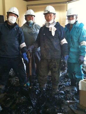 津波の二次災害でもある悪臭を放つヘドロをかきだす作業中の須藤と仲間たち