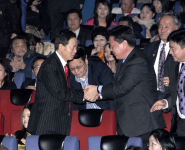 上映後にバトボルト内閣官房長官と固い握手を交わす角川春樹。