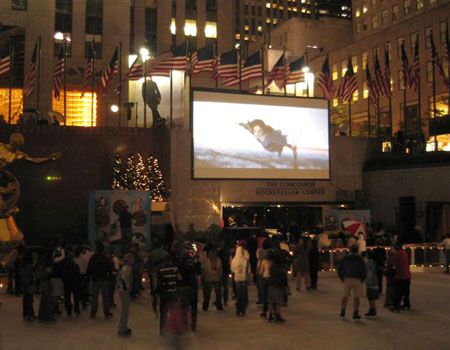 ニューヨーク、ロックフェラーセンターのスケートリンクで『ライラの冒険 黄金の羅針盤』の予告編を観る人々