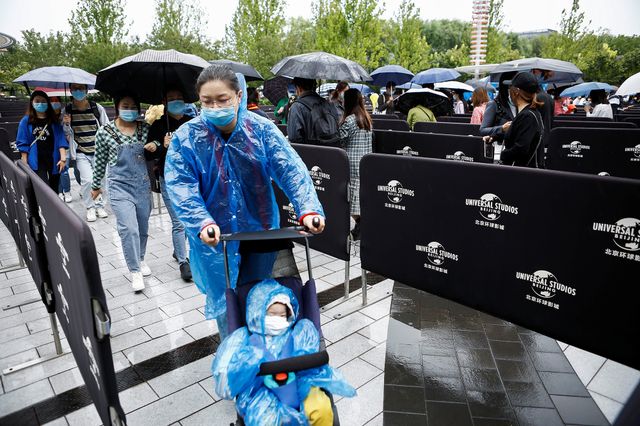 中国の北京で20日、米映画テーマパーク「ユニバーサル・スタジオ・北京」が開業した。新型コロナのパンデミック（世界的大流行）の影響もあり、構想から約20年の年月を経てようやく開園を迎えた。写真は雨の中、入場を待つ人たち